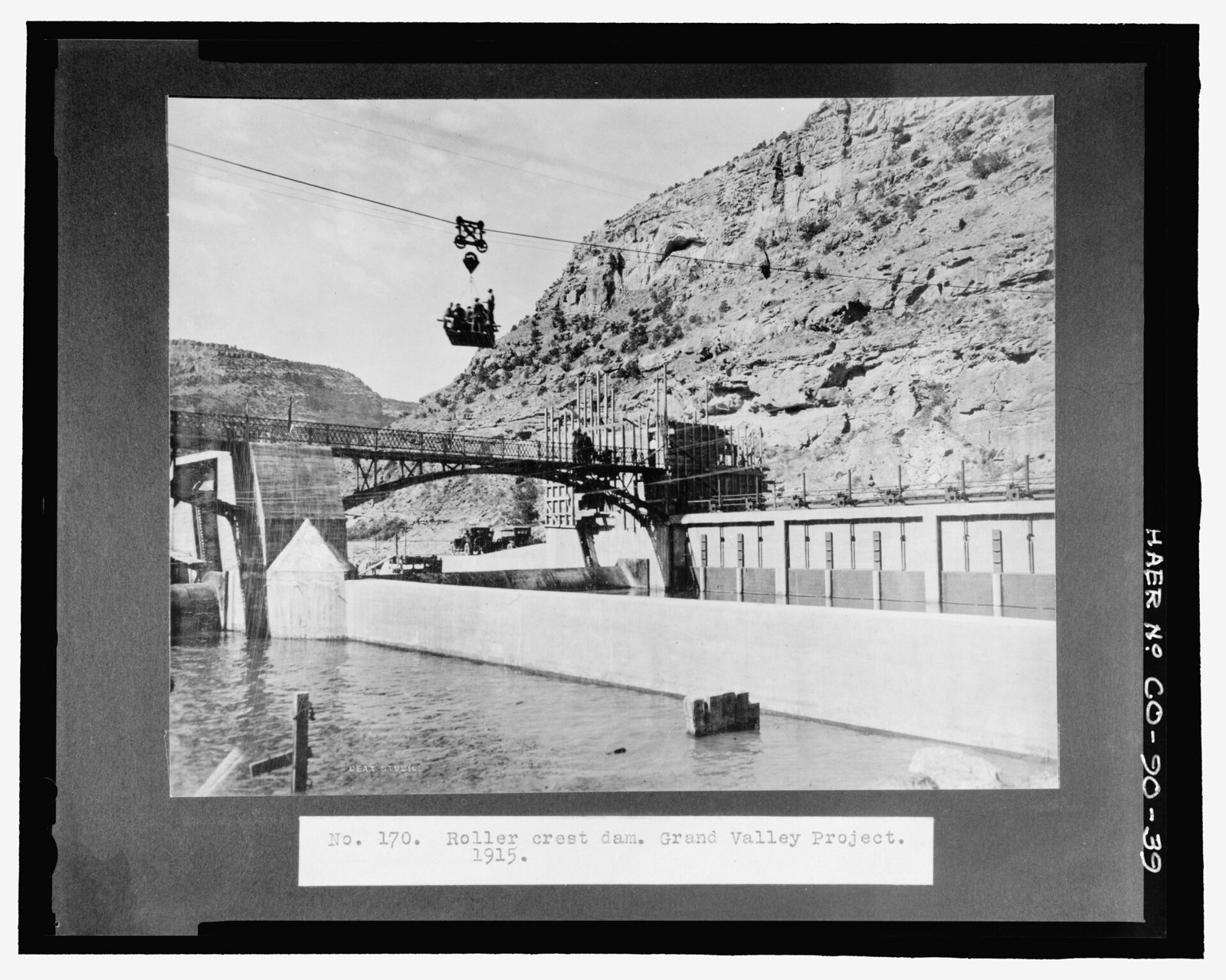 "No. 170. Roller crest dam. Grand Valley Project. 1915." Note cross-river cableway, and important component of the construction plant.