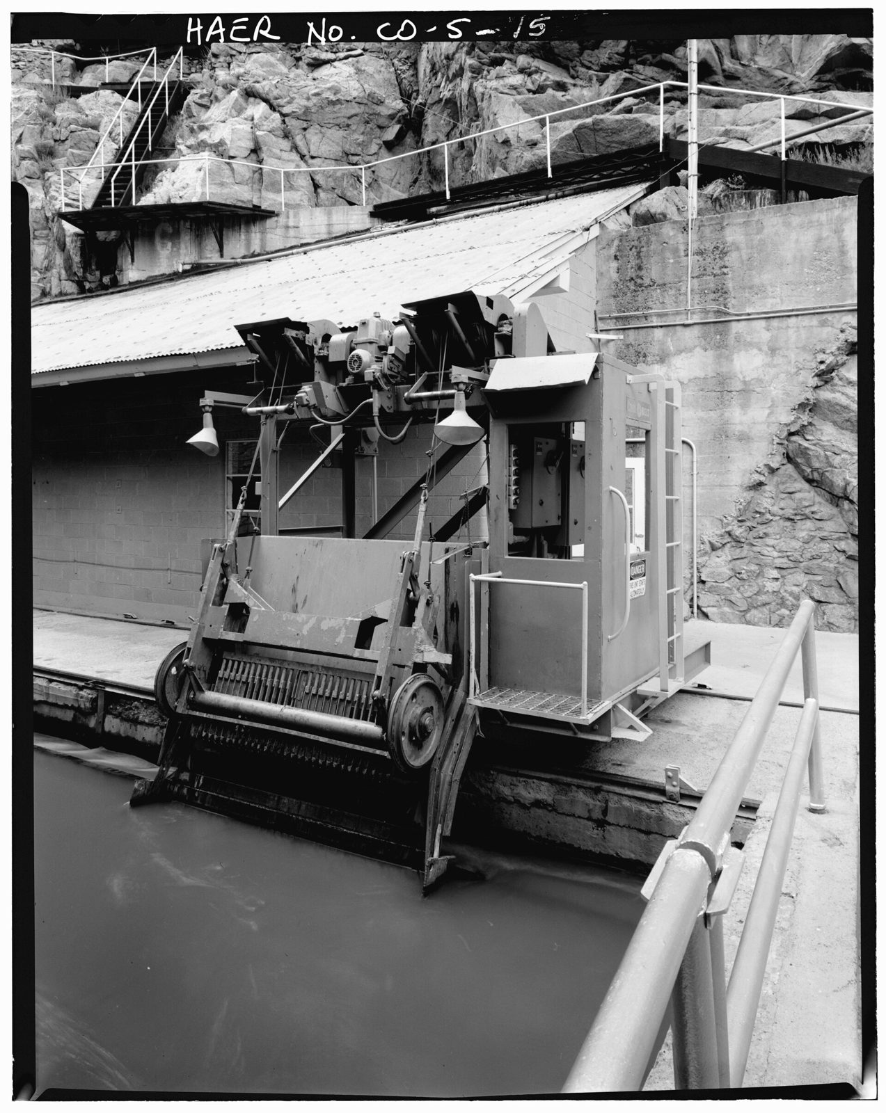 Detail of trash rake, for removing debris from the entrance to the diversion tunnel, gate house in background, view to the west.